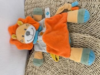 Doudou plat attache-tétine lion orange, jaune et bleu Tex