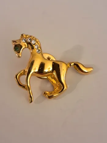 Pin's cheval dorée avec strass et pierre verte