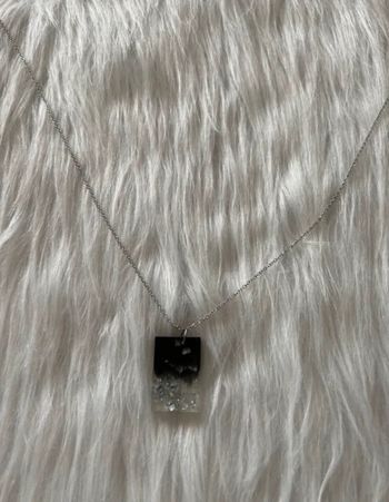 Le pendentif est fait main sur une résine noire avec paillettes argentées 🥰