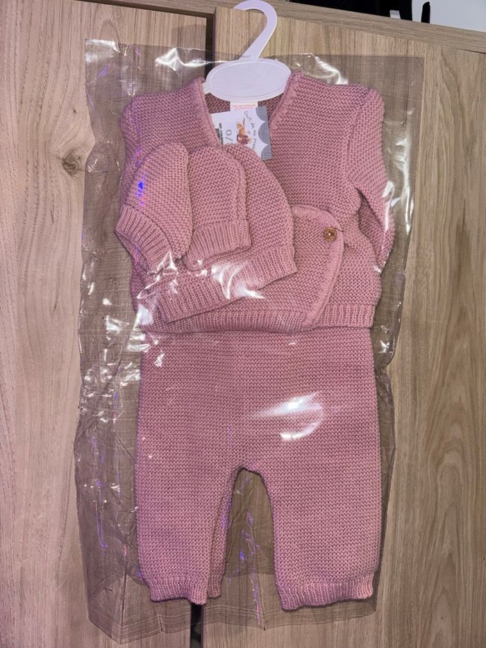 Ensemble de vêtements pour bébé. Tenue de naissance avec chaussons et bonnet, rose.