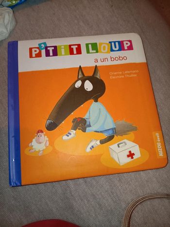 Livre plastifié loup à des défauts un trou et 1ere page un peu froissée