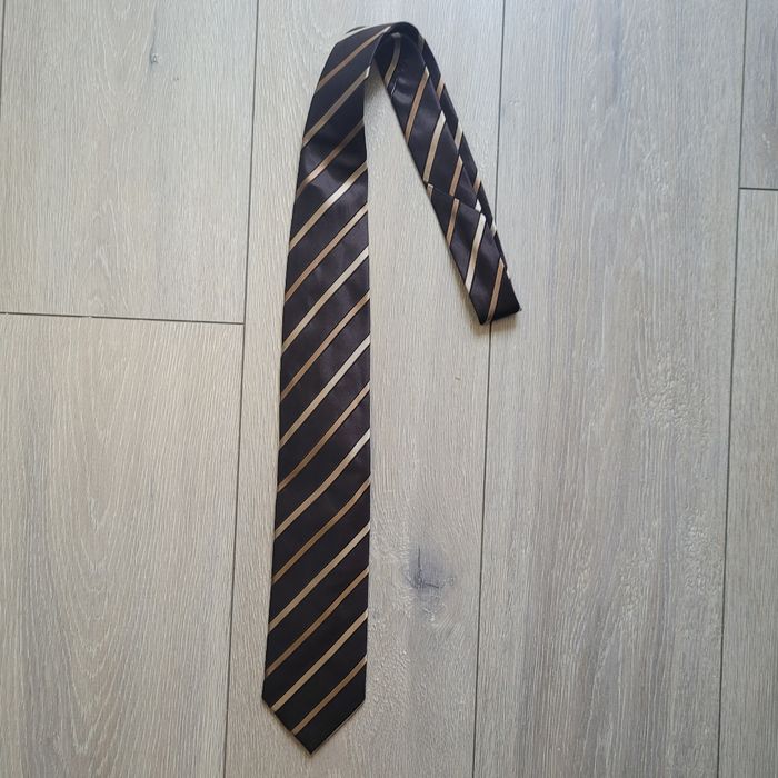 Très jolie cravate marron et doré rayée. Marque Celio club