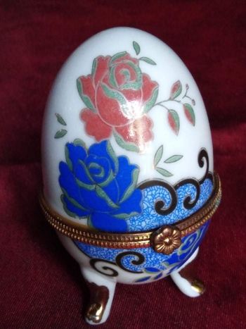 Oeuf en porcelaine avec des roses bleues et roses