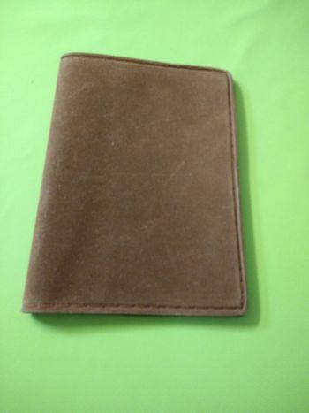 Portefeuille brun en plastique dessus imitation daim.