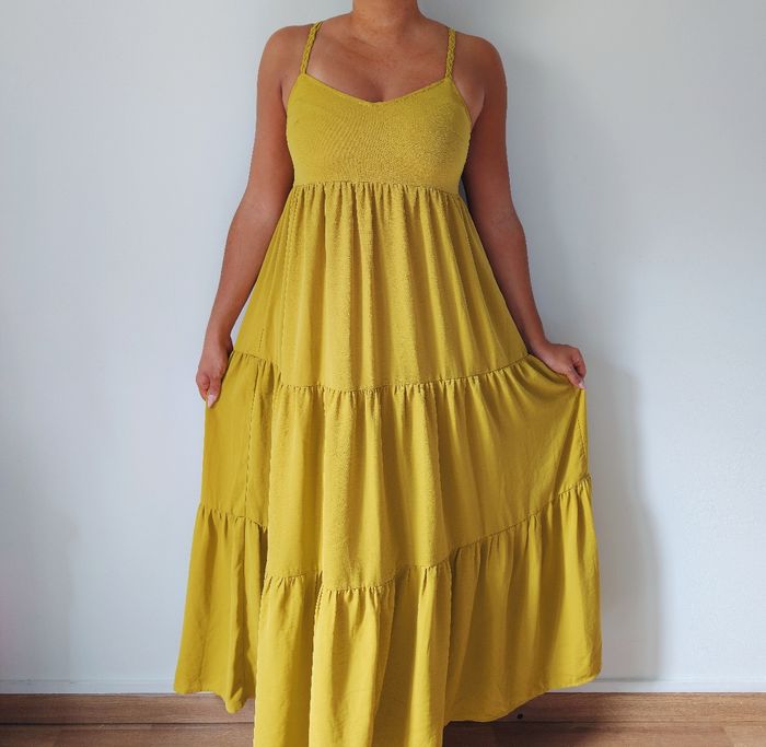 Robe longue maxi d'été à volants
Couleur jaune moutarde 
dos croisé 
look bohème moderne 
Marque Cache Cache 
Taille 36 S
Très bon état
