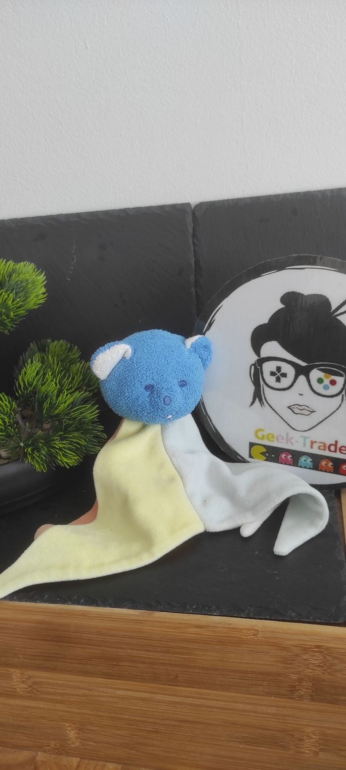 Doudou ours Musti Mustela triangle plat jaune orange bleu blanc Ancien Publicité