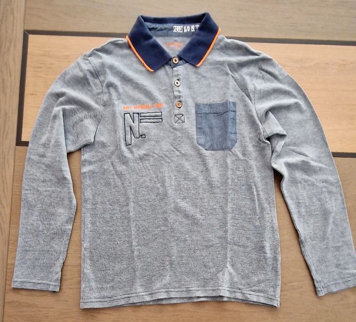 Polo bleu chiné orchestra 12 ans en très bon état