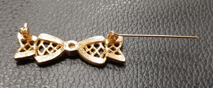 Très belle broche en metal doré et strass en forme de noeud - photo numéro 3