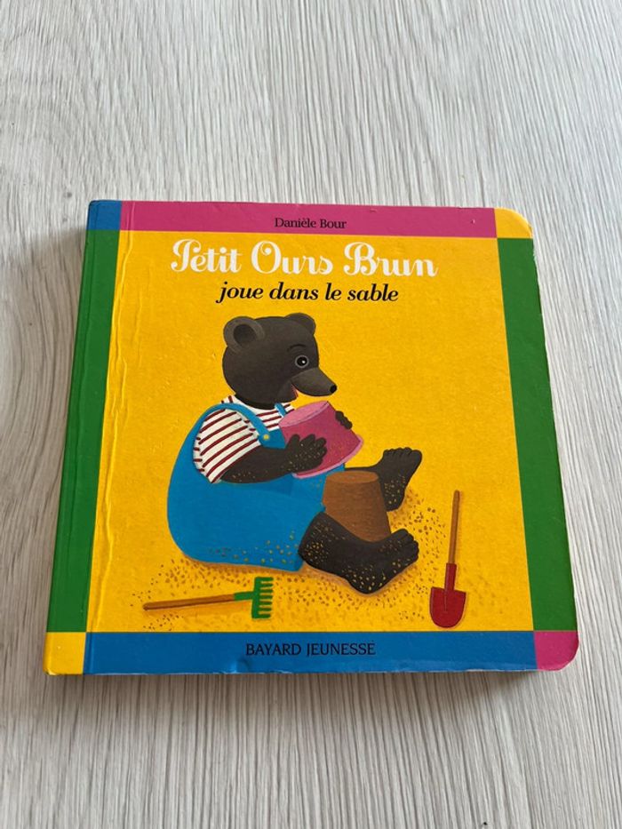 Petit ours brun joue dans le sable