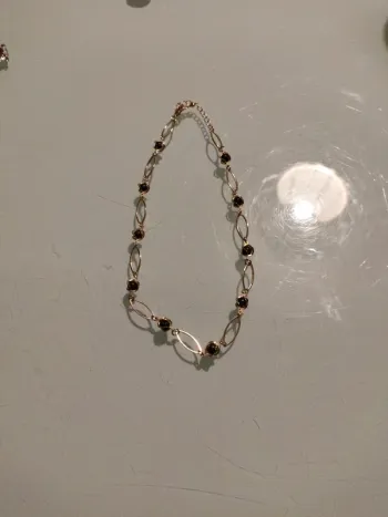 Collier doré avec maillons ovales et perles noires