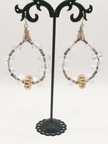 Orecchini lobo artigianali donna argento dorato color oro e vetro  pendenti a goccia Eleganti orecchini realizzati a mano con dettagli in argento e oro.

- Perle trasparenti sfaccettate.
- Elementi decorativi dorati.
- Chiusura a monachella argentata.
Mis