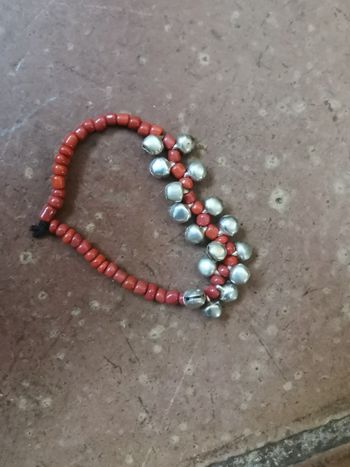 Bracelet élastique de perles couleur corail et les grelots argentés