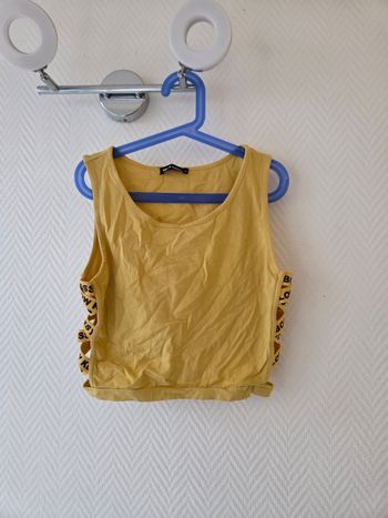 Crop top jaune sans manche avec lanière sur les coter laissant apparaître les cotes