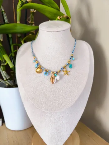 Collier doré et turquoise avec charms marins et fleur