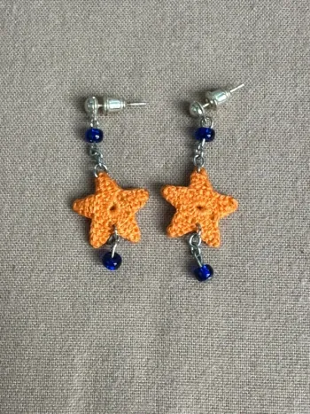 Boucles d'oreille étoile orange au crochet et petit strass bleu