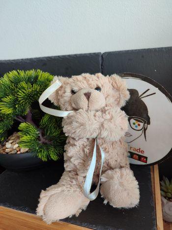 doudou peluche ours marron beige fourrure noeud bleu doré ruban Bras Croisés