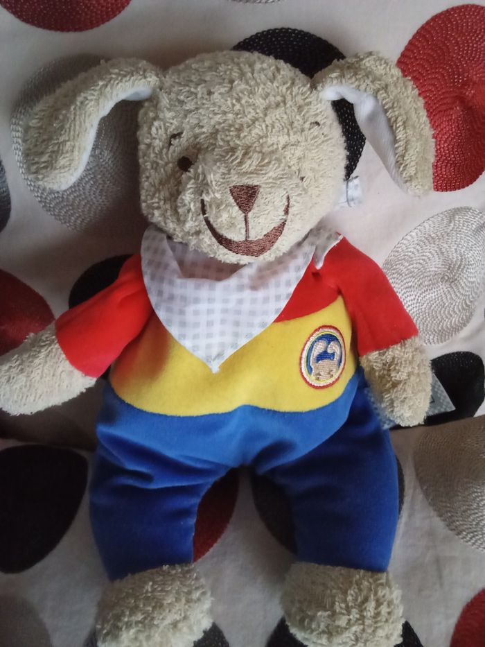 Doudou peluche Envog chien  ours beige marron clair haut rouge jaune bleu vintage ancien  peluche doudou chien  Envog S.C Galec  BP  23 92132 Issy les Moulineaux marque utilisée par Leclerc d'occasion