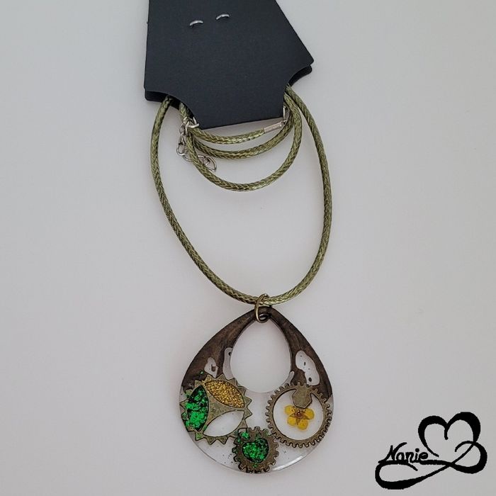 Pendentif transparent avec des engrenages et des paillettes vertes