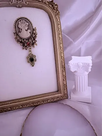 Broche dorée effet vintage avec camée et bijoux