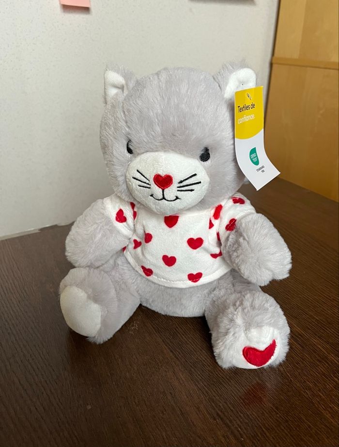 Peluche petit chat neuve  de couleur grise ,blanche et rouge .