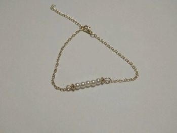 Bracelet doré avec perles blanches