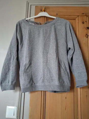 Sweat gris poche sur le devant et lacet en haut du dos