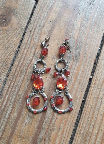 Boucles d'oreilles pendantes argentées et pierres rouges