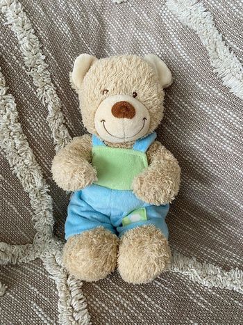 Peluche doudou 28cm tex ours beige salopette bleu et vert très bon état