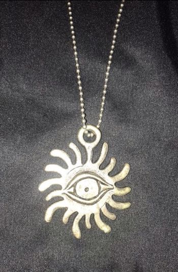 Collier couleur argenté motif œil soleil bon état bon état