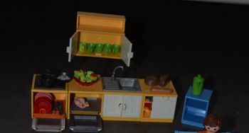 Playmobil, cuisine un lave vaisselle, un four, un évier, un meuble, un fauteuil, une table 2 chaises , une chaises haute , un biberon , des pommes dans un plat des assiettes , couteaux , cuillère , une théière un poulet des bouteil
