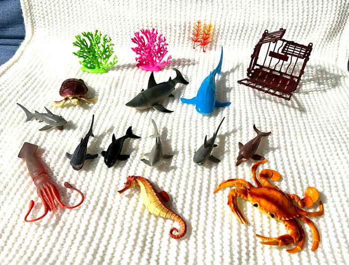 Crabe, requins, tortue, cage, hippocampe, algue, calamar.