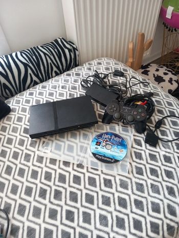 PlayStation 2 slim avec une manette et un jeu harry potter prisonnier et azkaban