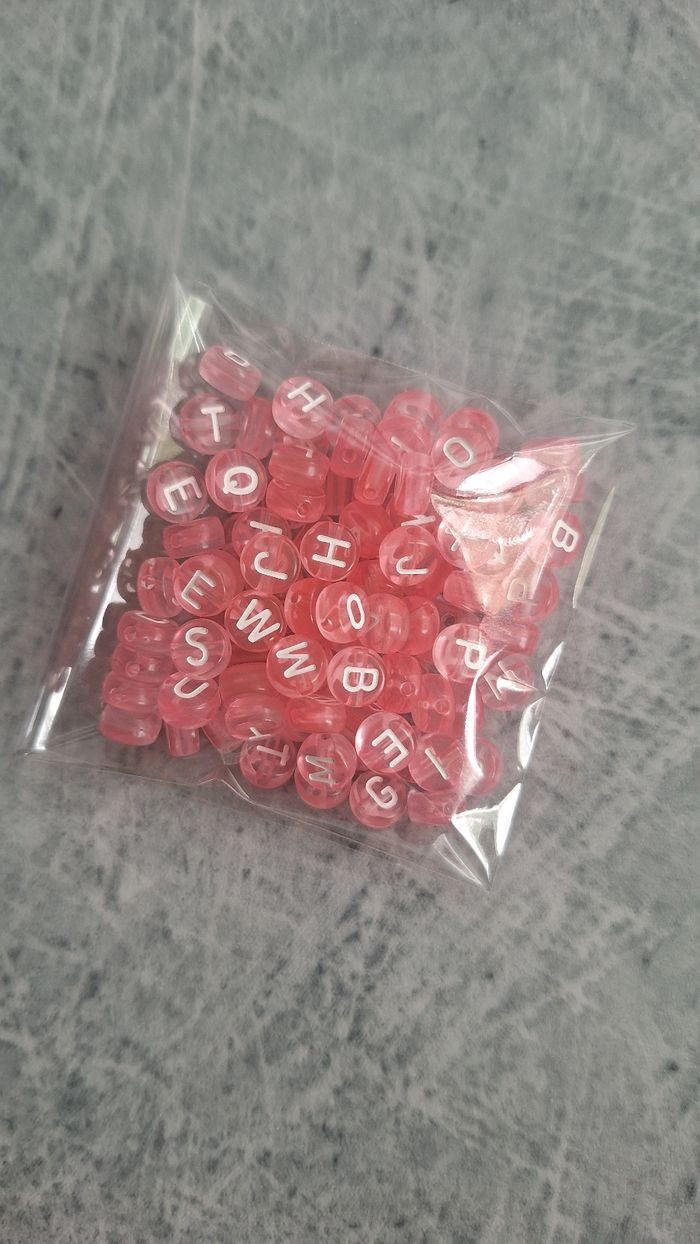 Perles roses lettres blanches