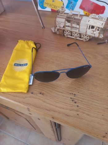 Une paire de lunettes de soleil ricard avec sa housse