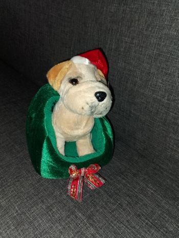 Petite peluche chien avec son bonnet dans son panier de Noël