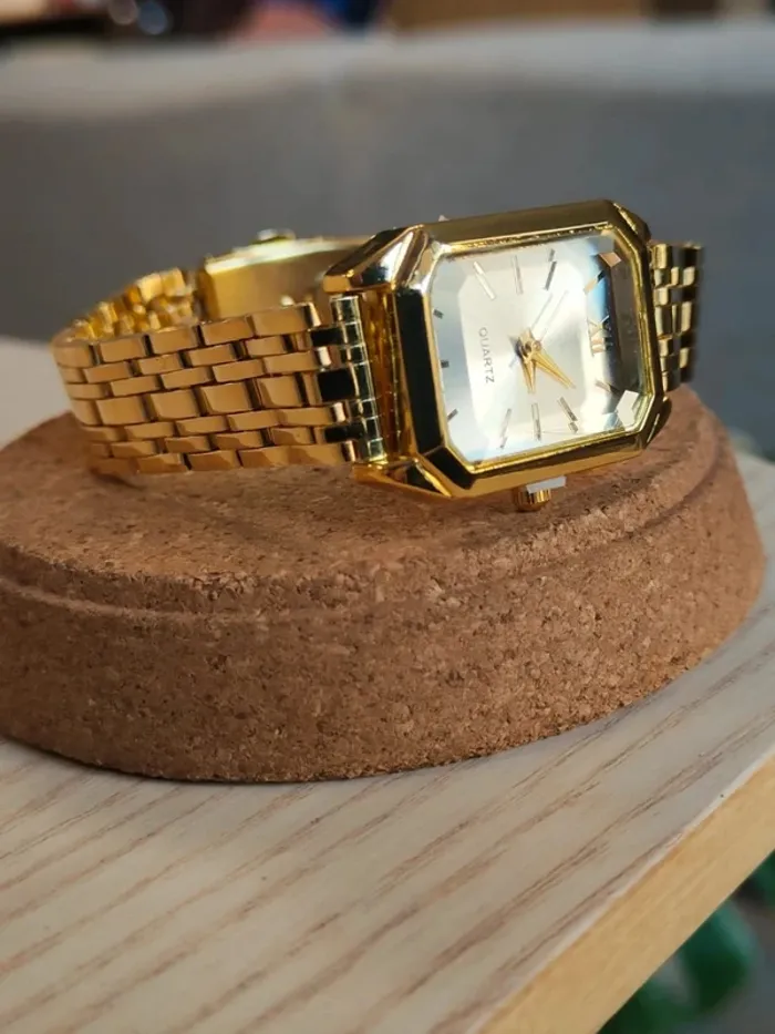 Montre blanche, dorée, rectangulaire en reliefs
