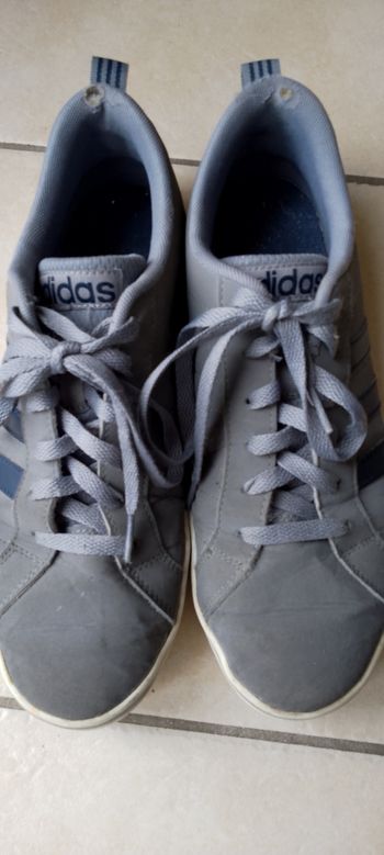 Jolie basket Adidas grises  bandes bleues marine 41,5 . Bon état. Usées en haut du talon voir photo. Pliure au niveau des orteils.