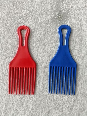 2 peignes afros (1 rouge et 1 bleu)