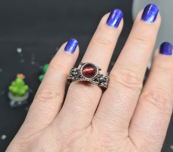 Bague fantaisie argentée avec pierre rouge portée par un homme et une femme