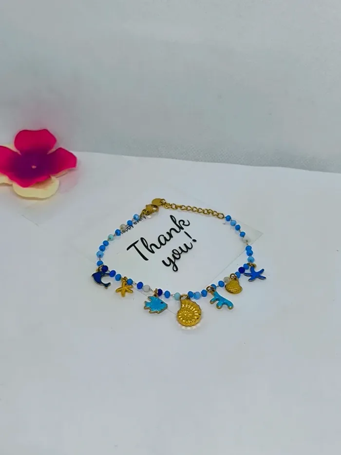 Bracelet doré et bleu avec perles de cristal et breloques de la mer