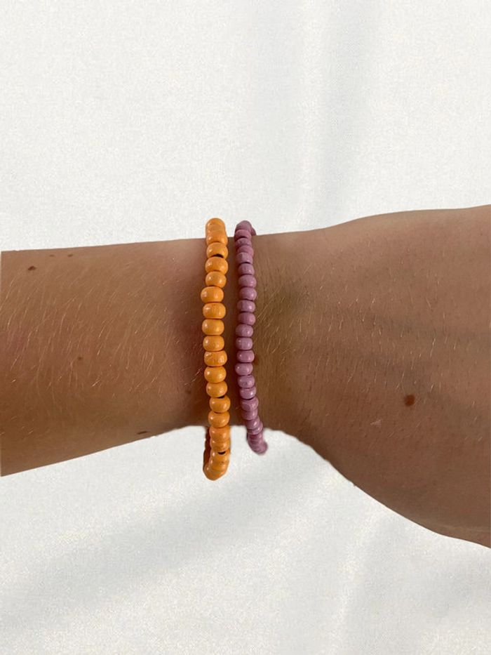 Deux bracelets perles orange et lila avec élastiques très bon état