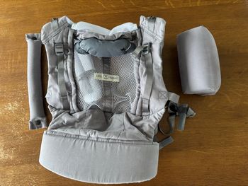 La différence principale est que le PhysioCarrier 2 est une solution tout-en-un (sans accessoire) avec une assise ajustable en largeur pour l’écart du bassin du nourrisson et une partie centrale ajustable en hauteur pour la taille de l’enfant (comme sur l