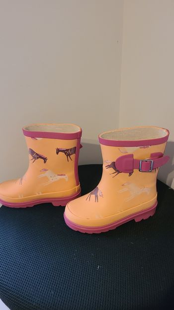 Bottes en caoutchouc pour enfants, orange, combinées avec du rose. Elles ont une semelle semi-épaiss
