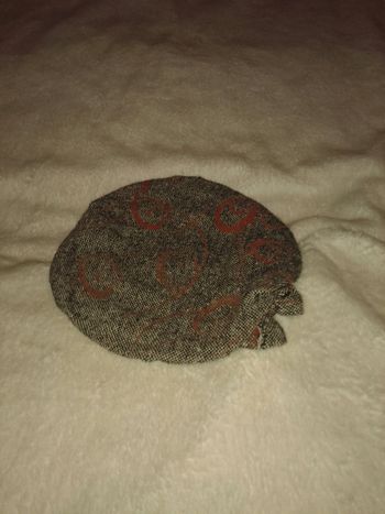 Joli béret gris et rouge.