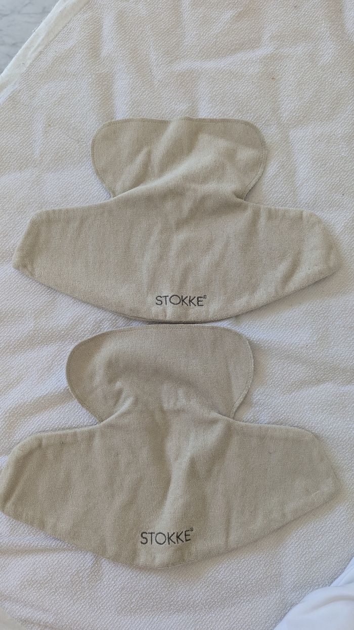 2 bavoirs porte bébé beiges Stokke neufs