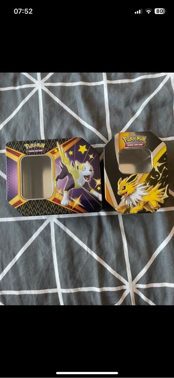 deux boîtes métalliques collector officielles du jeu de cartes Pokémon.
