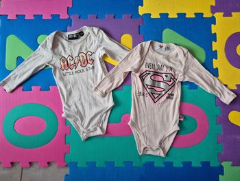 Lot de 2 bodies AC/DC + SuperGirl 18m
