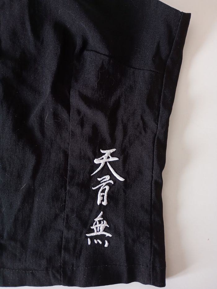 Débardeur noir avec des  bretelles. Taille S . Fermeture éclair. Signes chinois blancs . Viscose polyamide et élasthanne. Très bon état - photo numéro 3