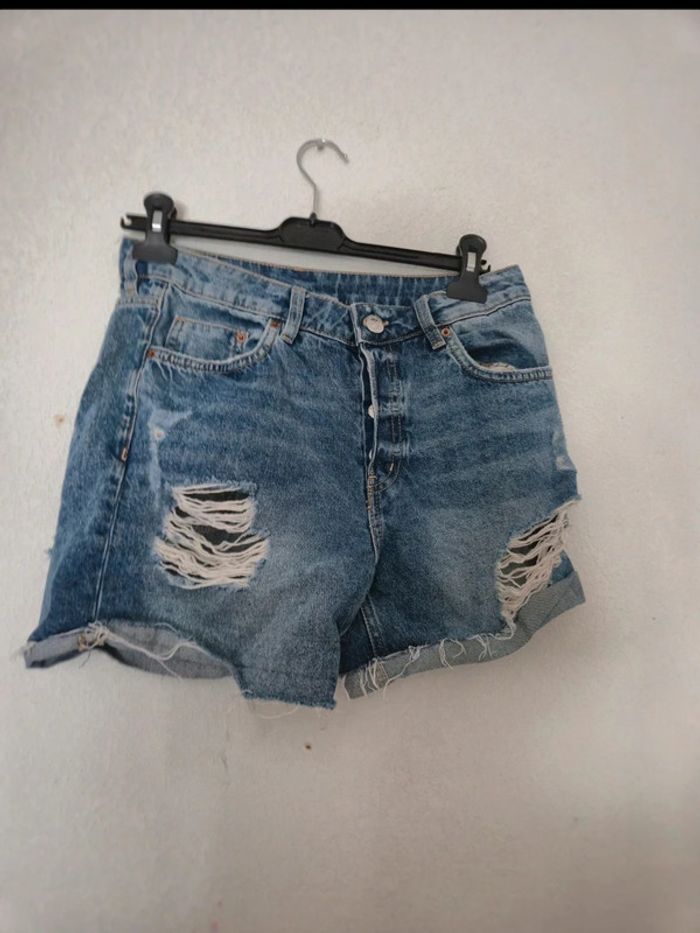 Short bleu en jean effet troué, excellent état. Taille 36