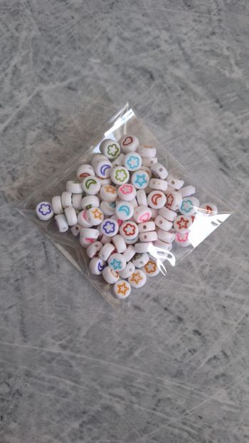 Perles blanches symboles multicolores